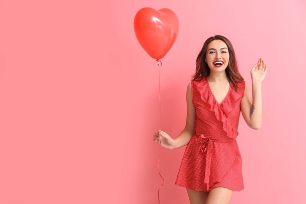 Beautiful young woman with balloon on color background. Valentine's Day celebration - Foto, Bild