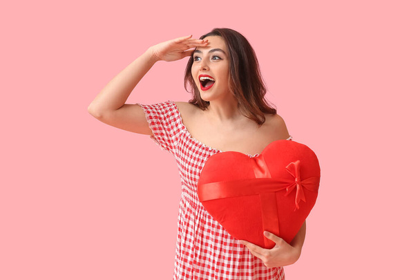 Beautiful young woman with red heart on pink background. Valentine's Day celebration - Photo, Image