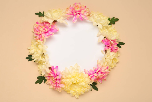 Frame of beautiful chrysanthemums on beige background, flat lay. Space for text - Fotoğraf, Görsel