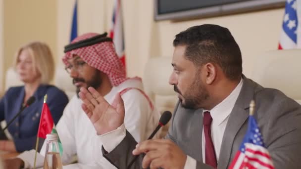 Orta Doğu ülkesinin ciddi erkek siyasetçisinin farklı ülkelerden siyasi liderlerle basın toplantısında izleyicilere konuşma yaparken belini kaldır. - Video, Çekim