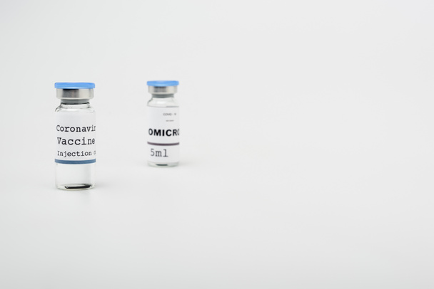 vials with covid-19 and omicron vaccine on grey background with copy space - Valokuva, kuva