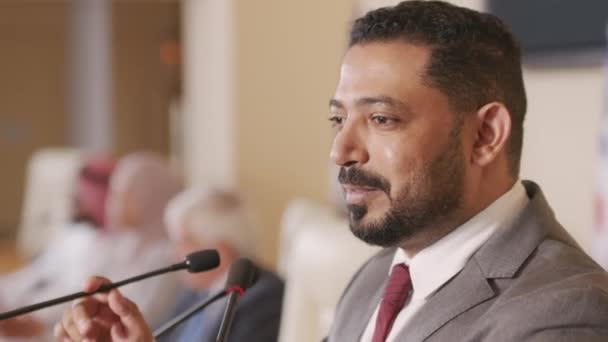 Mellkasfelvétel a közel-keleti ország középkorú férfi politikai vezetőjének beszédéről a tribunuson, ahogy a konferenciateremben beszédet mond a közönségnek - Felvétel, videó