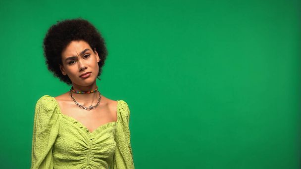 Skeptický africký Američan žena při pohledu na kameru izolované na zelené - Fotografie, Obrázek