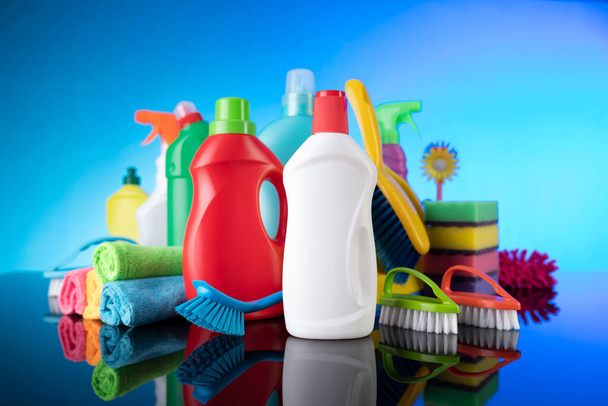 Schoonmaakmiddelen voor huis en kantoor. Kleurrijke schoonmaak kit op blauwe achtergrond. - Foto, afbeelding
