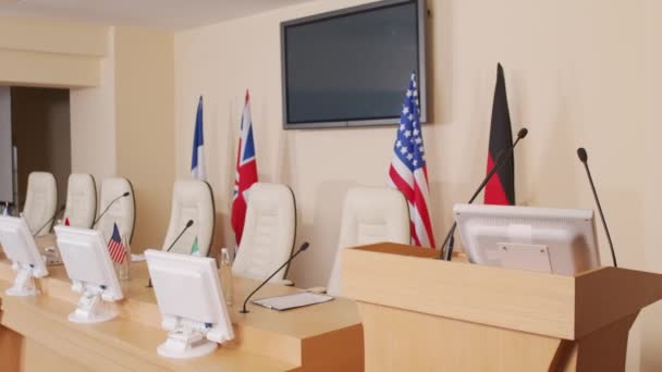 Ei yleiskatsausta tribuunin ja pitkä puinen pöytä varustettu mikrofoneilla ja tietokonenäyttöjä poliittisten johtajien istua lehdistötilaisuudessa - Materiaali, video