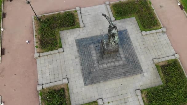 Lenin monument op een sokkel met duiven. Man met een kap met uitgestrekte hand  - Video