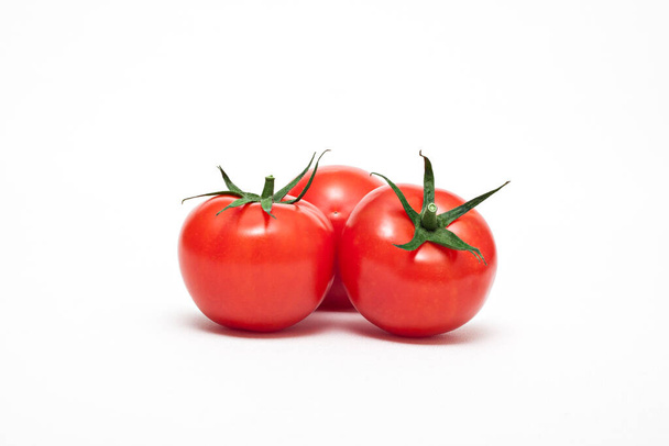 Купка органічних стиглих червоних помідорів на білому тлі
. - Фото, зображення
