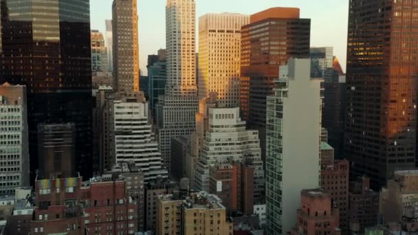 Magas épületek a belvárosban alkonyatkor. Magas irodai tornyok, napnyugtakor világítanak. Manhattan, New York City, Amerikai Egyesült Államok - Felvétel, videó