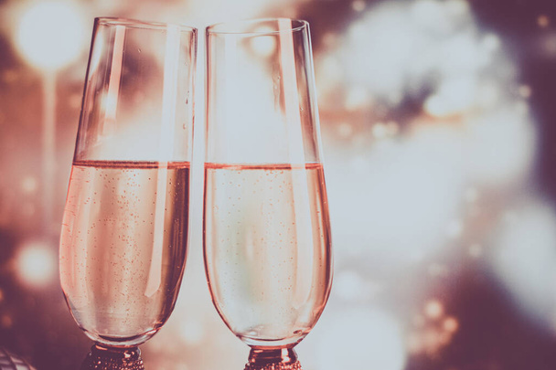 Champagne glasses on sparkling background. Two champagne glasses ready to bring in the New Year. - 写真・画像