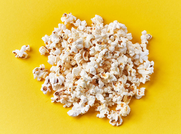 Bunch of salty popcorns on a yellow background - Фото, зображення
