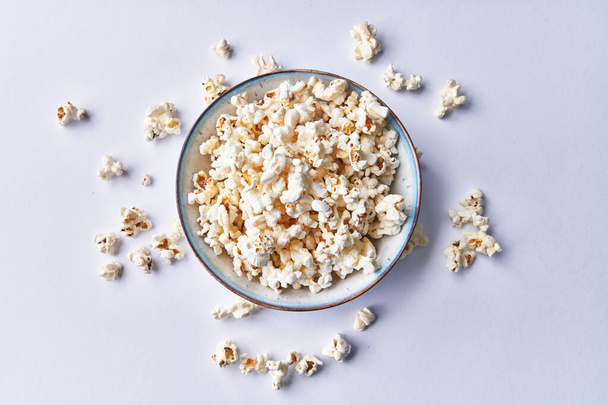  Bowl of salty popcorns isolated on a white background - 写真・画像