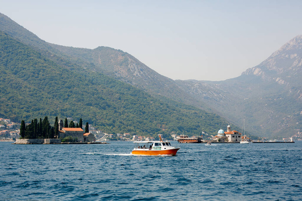 Pleasure boat sails past the island of St. George in the Bay of Kotor - Фото, изображение