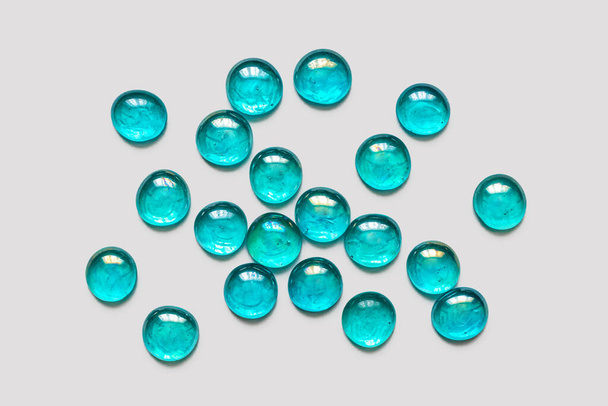 Bright, transparent, glass stones, turquoise color. Decorative for decoration and home creativity, on a light background - Fotó, kép