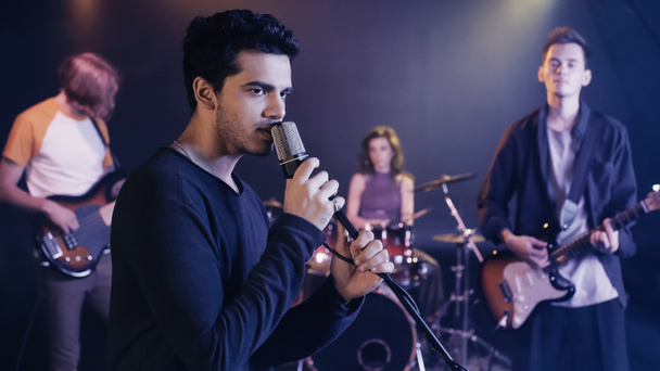 young singer performing song with music band - Foto, Bild