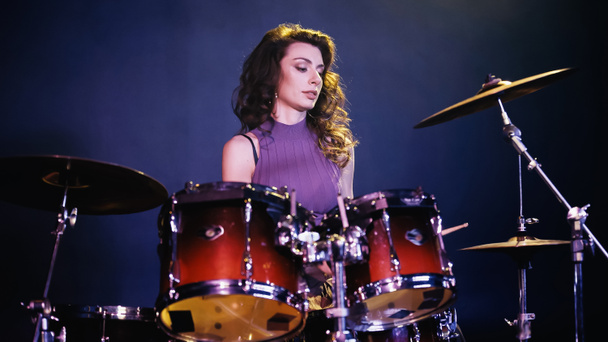 pretty drummer playing on drums during performance on stage - Foto, afbeelding