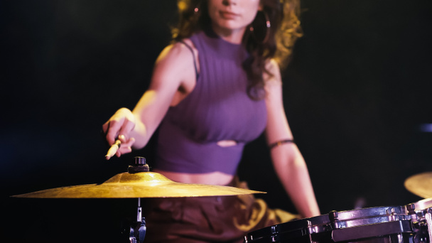 обрізаний вид розмитого барабанщика, який грає на барабанах під час виступу на сцені
  - Фото, зображення
