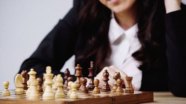 partial view of blurred businesswoman playing chess isolated on white  - Photo, image