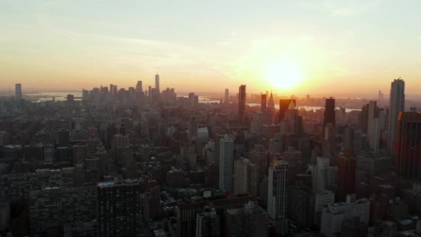 高層ビルの高層ビルが立ち並ぶ街の開発の上に美しい夕日。米国ニューヨーク市マンハッタン - 映像、動画