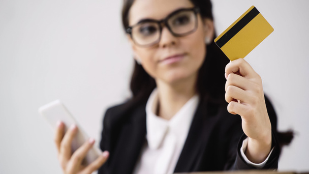 бізнес-леді робить покупки в Інтернеті, тримаючи смартфон і кредитну картку ізольовані на білому
  - Фото, зображення