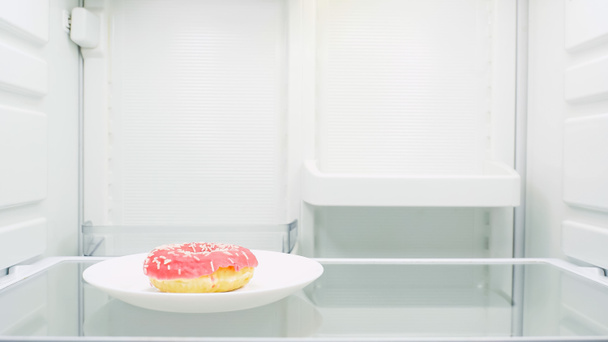 sweet glazed doughnut on plate in fridge - Fotoğraf, Görsel