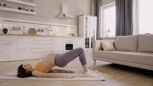 Pregnant woman training on fitness mat at home  - Fotografie, Obrázek
