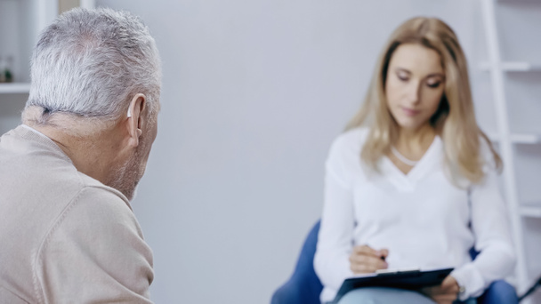 hombre de mediana edad cerca de psicoterapeuta borrosa  - Foto, imagen