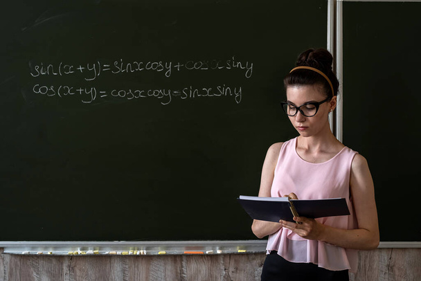 female teacher writing math formulas, cos and sin. education concept - Photo, Image