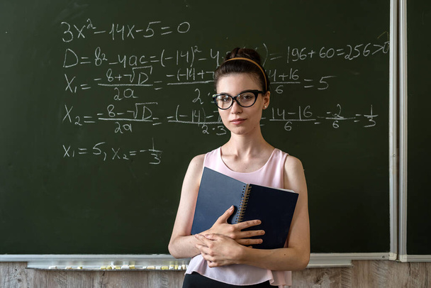 νεαρή φοιτήτρια έγραψε μαθηματικούς τύπους στο chalkboard, έννοια της εκπαίδευσης  - Φωτογραφία, εικόνα