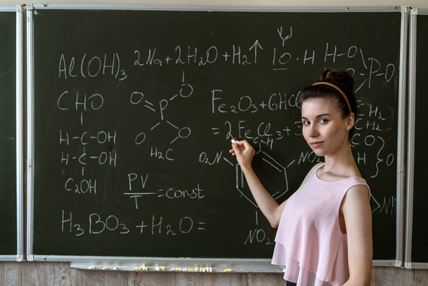δάσκαλος χημείας κατά του χημικού τύπου του πίνακα explane, εκπαιδευτική έννοια - Φωτογραφία, εικόνα