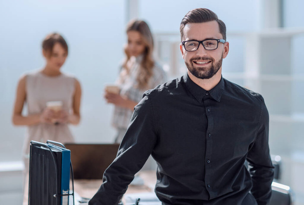 smiling young business man standing in office - Φωτογραφία, εικόνα