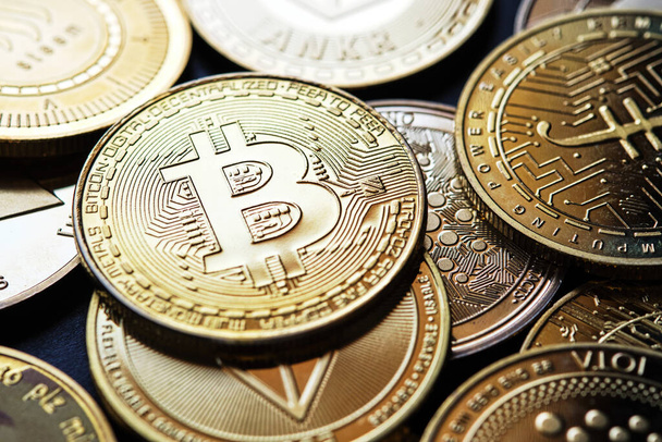 Closeup of bitcoin coin along with other golden cryptocurrencies - Foto, Bild