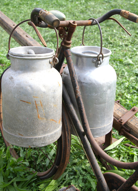 fiets van de melkman met twee oude melk blikjes - Foto, afbeelding