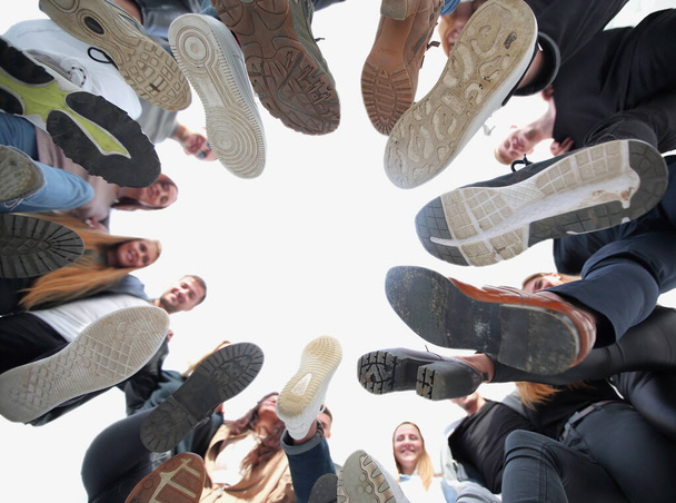 bottom view. cheerful young people standing in a circle - Foto, Imagem