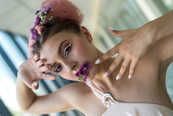 Retrato de moda de mujer joven con flores en la boca - Foto, Imagen