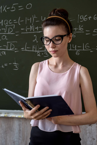  studente universitaria che scrive sulla lavagna completando equazioni matematiche. concetto di istruzione - Foto, immagini