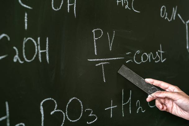 female teacher explane chemical formulas near chalkboard, education concept - Foto, Bild