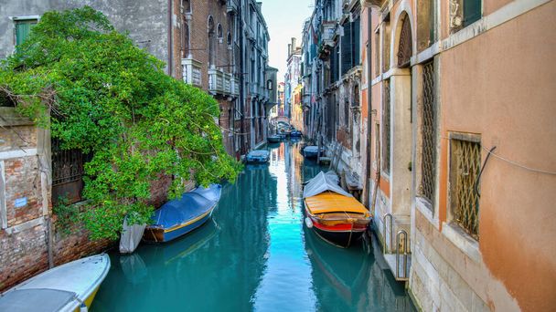 Een klein kanaal in Venetië met prachtige kleurrijke huizen, Italië. Venetië is een stad in het noordoosten van Italië en de hoofdstad van de regio Veneto.. - Foto, afbeelding