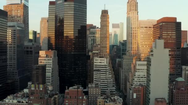Nykyaikaiset korkeat rakennukset, joissa kiiltävät lasijulkisivut heijastavat värikästä auringonlaskua. Manhattan, New York City, Yhdysvallat - Materiaali, video