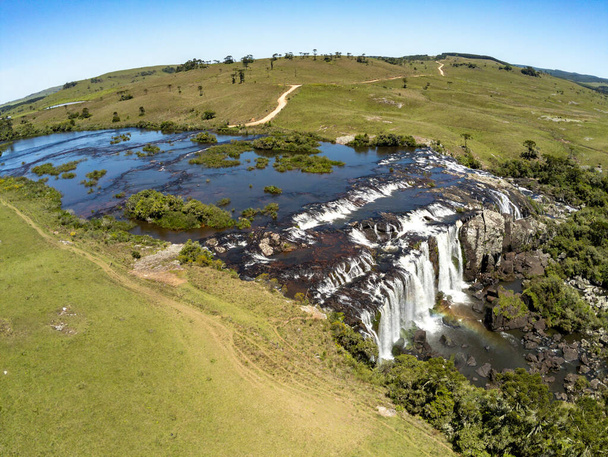 Aerial view of Waterfall with fields, rocks and dirty road, Jaquirana, Rio Grande do Sul, Brazil - Foto, imagen