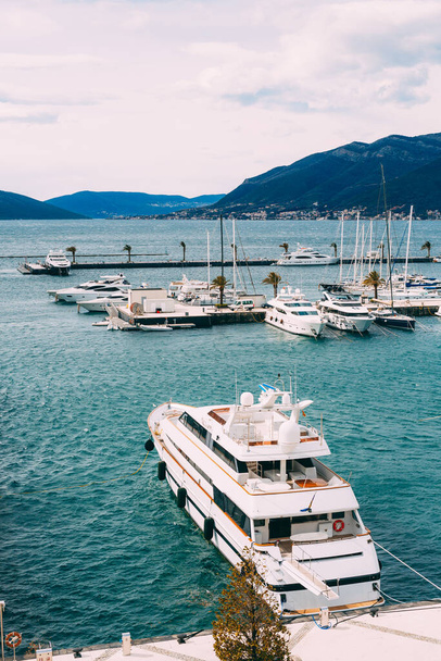 Double-decked white yacht is moored to the pier. Porto, Montenegro - Фото, изображение