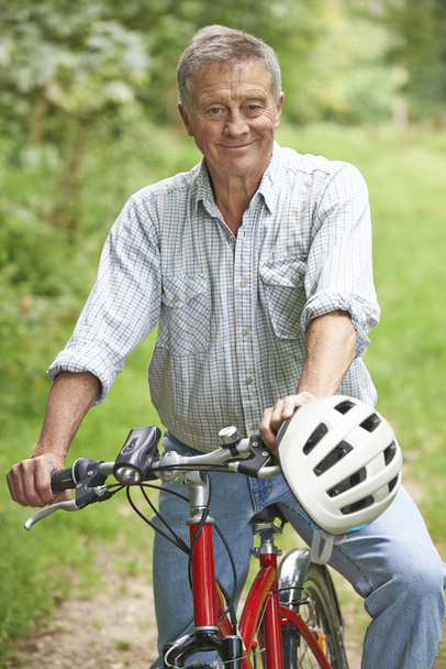 Homme âgé appréciant la randonnée à vélo dans la campagne
 - Photo, image