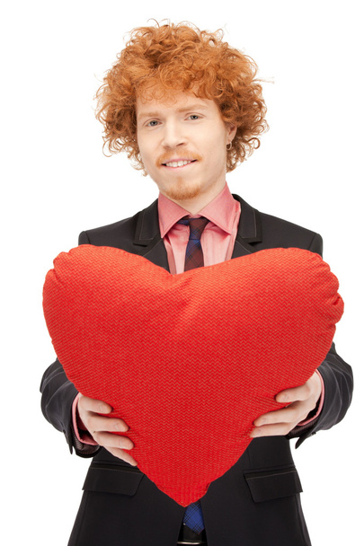 Homem bonito com travesseiro vermelho em forma de coração
 - Foto, Imagem