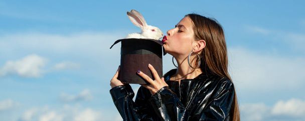 Easter banner with bunny woman. Magician rabbit, stylish clothing. Alice in Wonderland. Plush bunny. Fashion concept. - 写真・画像
