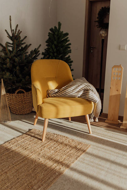 Yellow armchair with blanket on it for Christmas background - 写真・画像