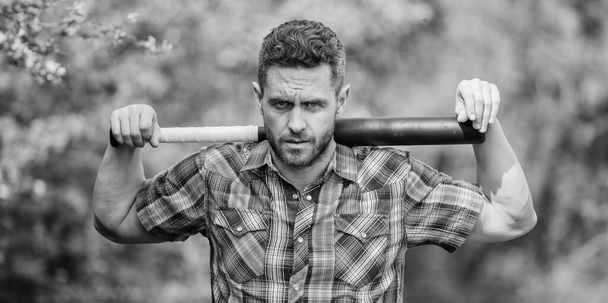 Principle concept. Confident in his strength. Bully guy in nature with cudgel. Wild energy. Power and strength. Feel my strength. Man unshaven strict face hold black baseball bat. Strong temper - Photo, Image