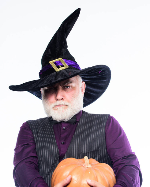 Stargazer in holiday costume. Traditional food. bearded man ready for halloween party. happy halloween. mature man magician in witch hat. evil wizard hold orange pumpkin. the highway to hell. - Φωτογραφία, εικόνα