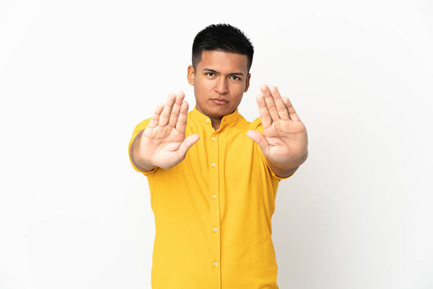 Молодой эквадорский мужчина на белом фоне делает остановку жеста и разочарован - Фото, изображение