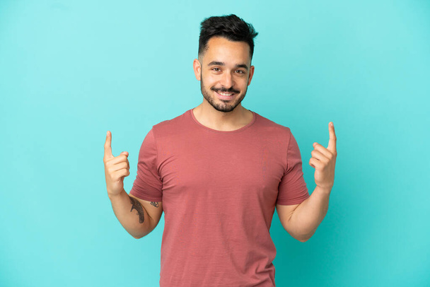 Young caucasian man isolated on blue background pointing up a great idea - Foto, Imagem