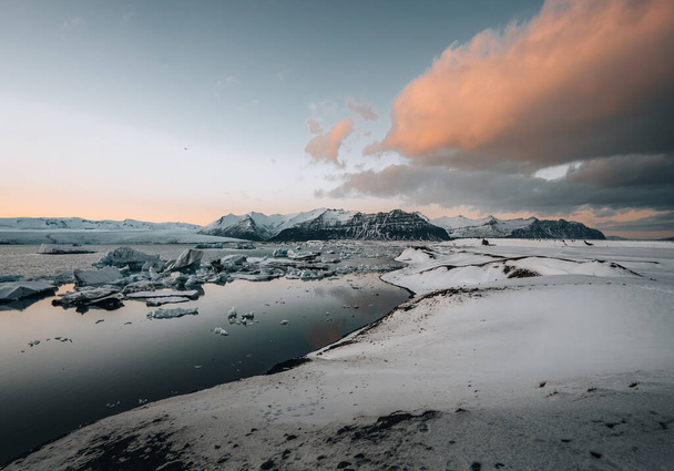 Aerial drone panorama of famous lake Joekulsarlon glacial lagoon and diamond beach with its icebergs and ice floes in Iceland during sunset twilight in winter. - Zdjęcie, obraz