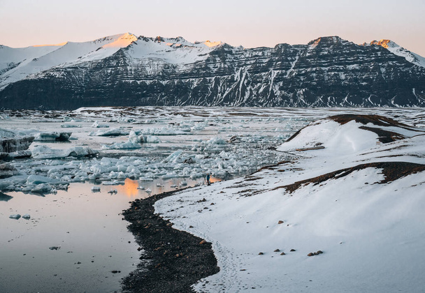 Panorama drona lotnicza słynnego jeziora Joekulsarlon laguny lodowej i diamentowej plaży z góry lodowej i kry lodowej w Islandii podczas zachodu słońca w zimie. - Zdjęcie, obraz